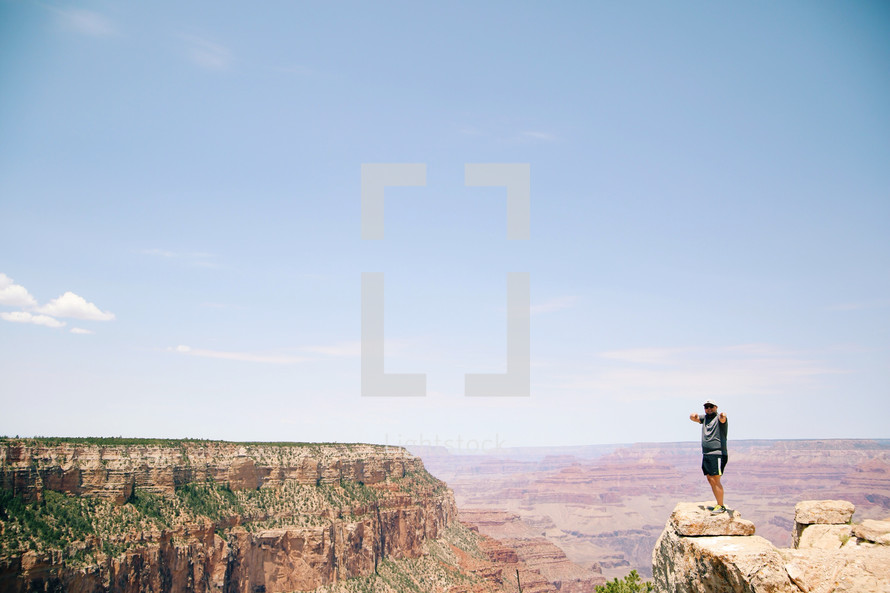 man standing at the edge of a cliff at the Grand Canyon 