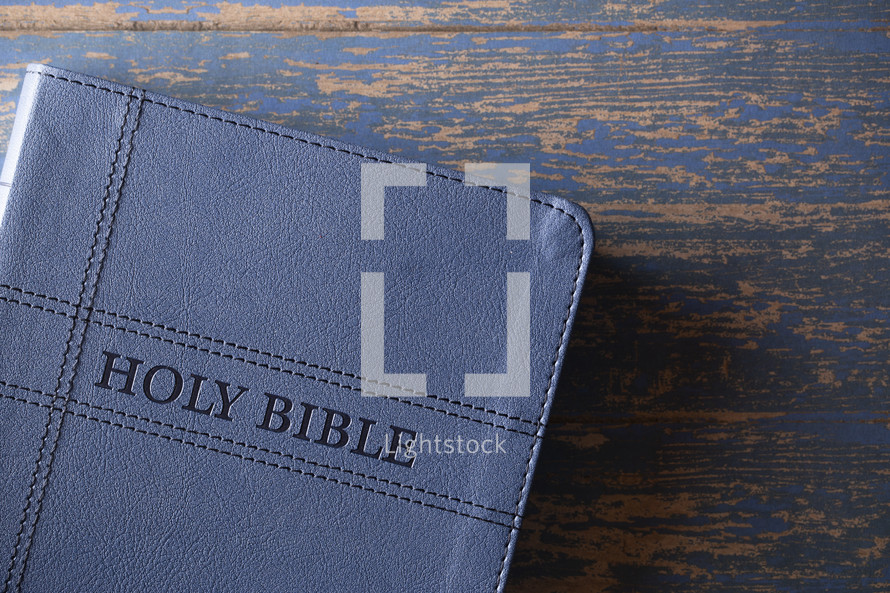 Bible on blue wood background 