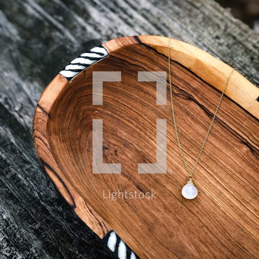 gold necklace in a wooden bowl 