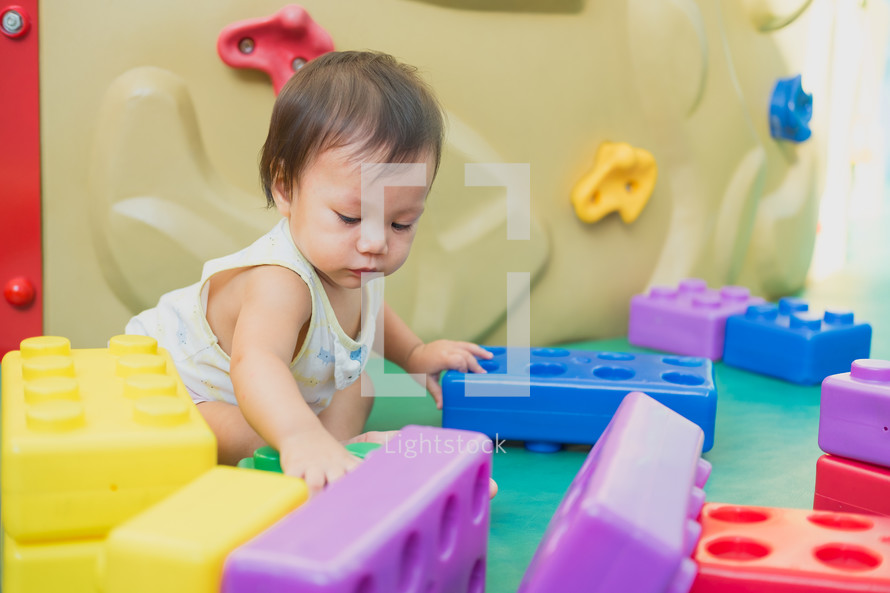 infant playing with blocks 