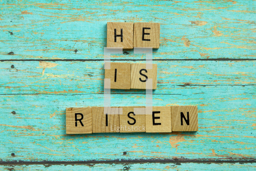 He is Risen on teal blue wood boards 