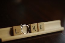 word Love out of scrabble pieces and engagement ring
