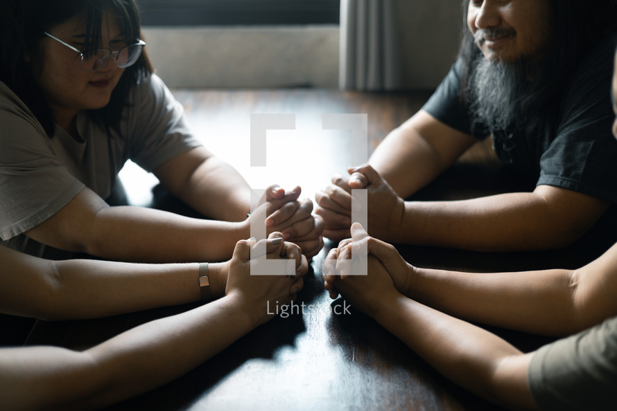 Group praying with folded hands together