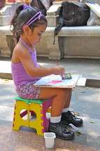 Child painting with water color paints 