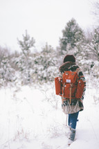 woman backpacking through snow