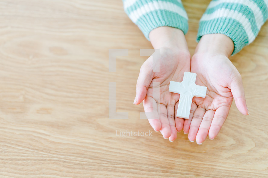 a cross in cupped hands 