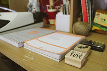 vintage typewriter, notepads, and rubber stamps on a desk 