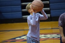 a child shooting a basketball 