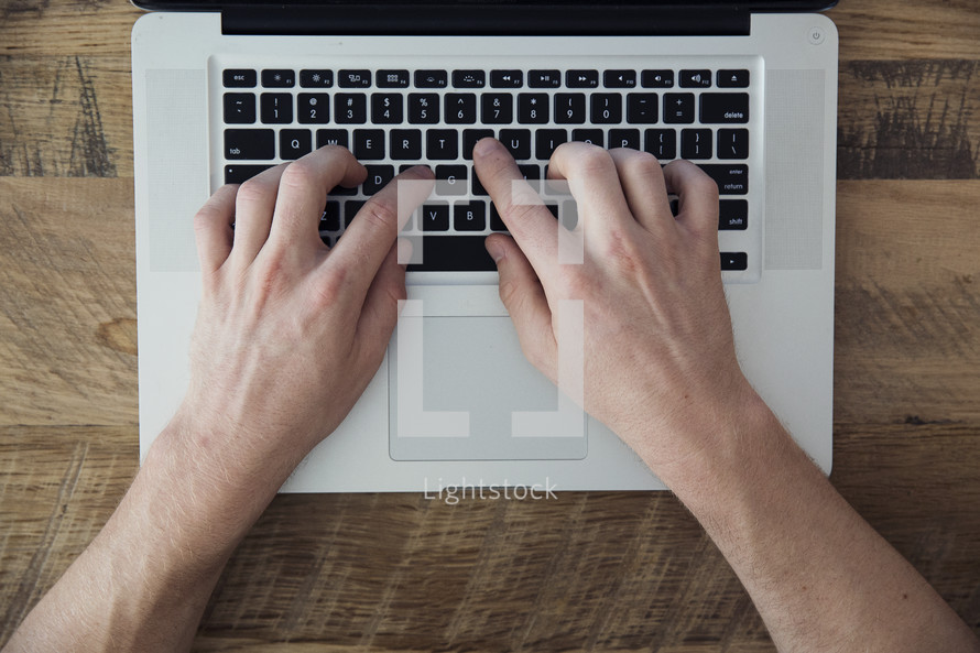 hands typing on a laptop computer 