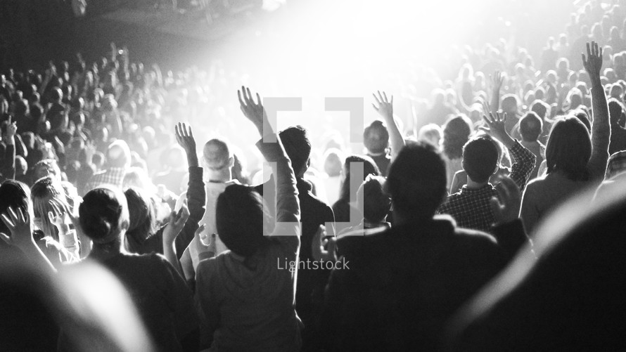 Hands raised in worship at a concert.