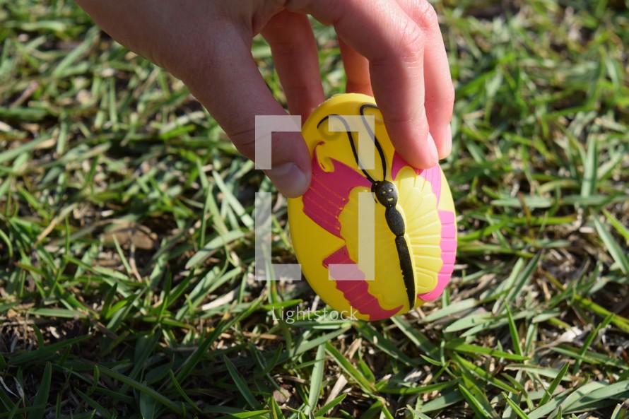 A child picking up an Easter egg at an Easter egg hunt