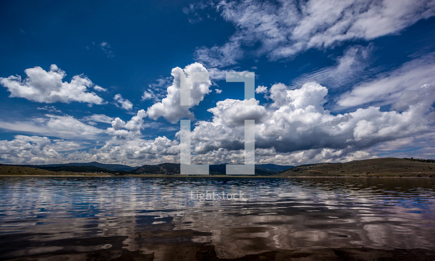 blue sky and clouds over water in a lake 
