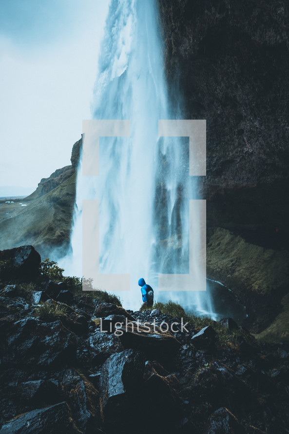 person standing in front of a waterfall 