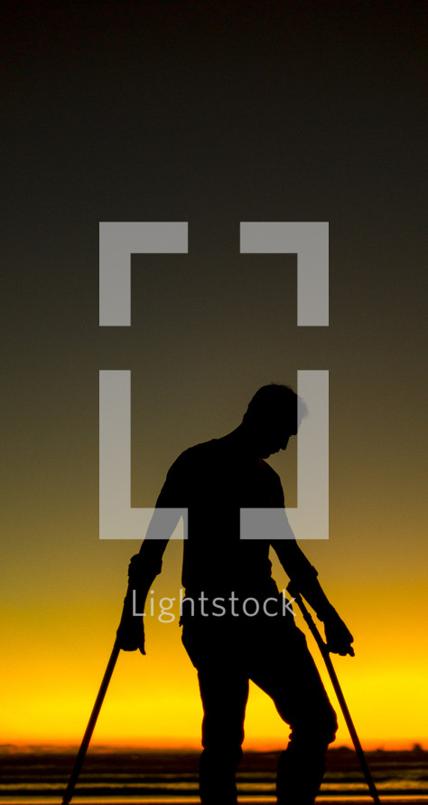 silhouette of a crippled man in arm braces