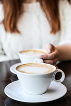 woman with her hand on a latte cup 