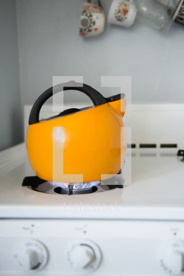 yellow kettle on a gas stove 