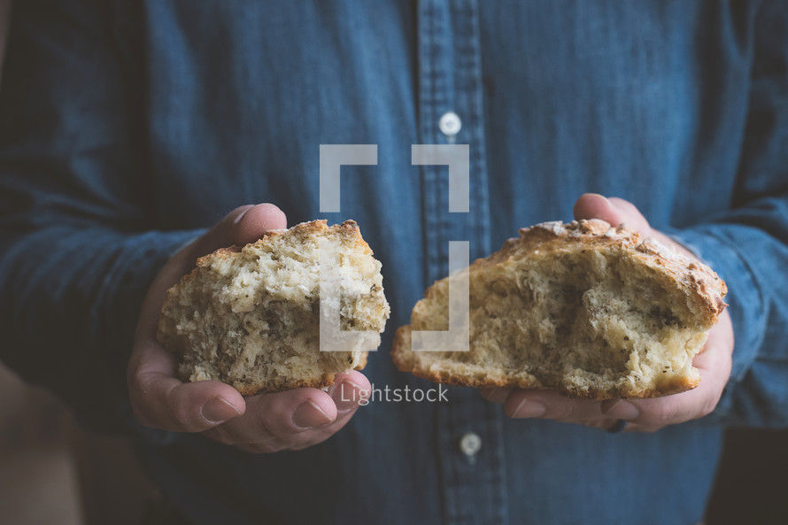 Person holding a torn loaf of bread