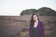 Smiling woman standing in a field.