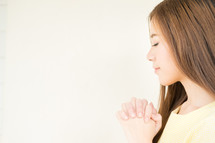 face of a young woman praying 