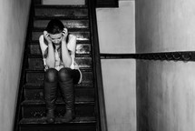 upset teen girl sitting on stairs 