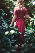 a woman walking through a garden 