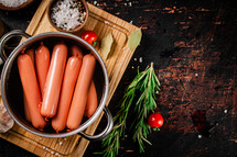 Delicious sausages boiled on the table. On a black background. High quality photo