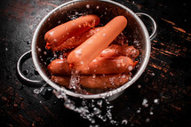 Delicious sausages boiled on the table. On a black background. High quality photo