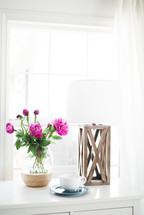 flowers in a vase, coffee cup and saucer, and candle holder 