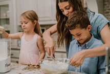a mother baking cookies with her kids 