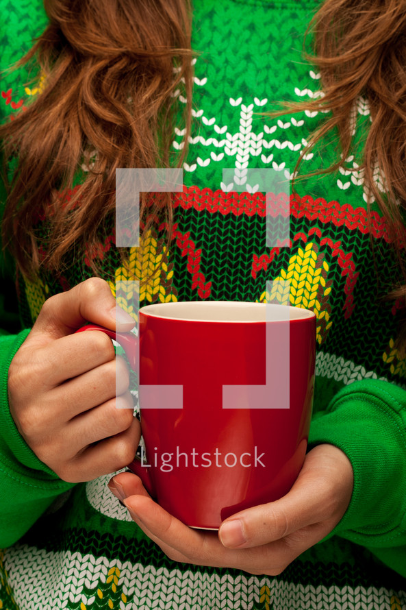 a woman in a Chrisms sweater t-shirt holding a mug 