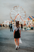 a teen girl walking around a fair 