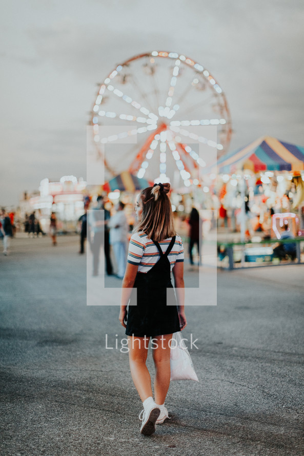 a teen girl walking around a fair 