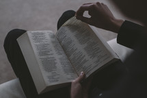 A person turning the page of a Bible.