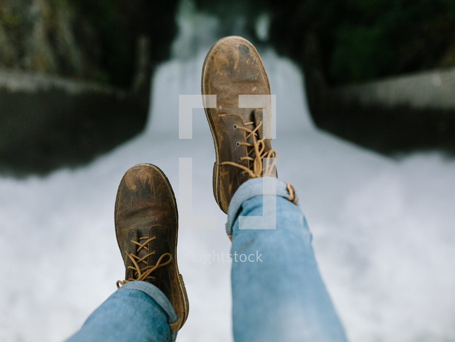 boots hanging over a waterfall 