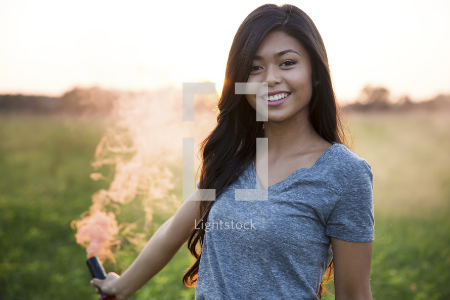 young woman holding a smoke flare 