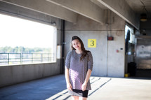 a woman standing in a parking garage 
