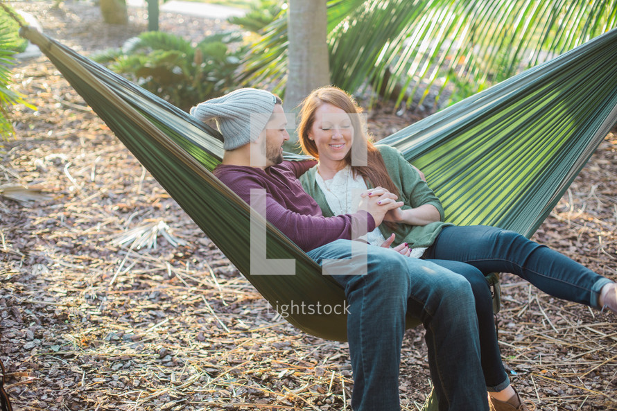 a couple sitting in a hammock together 