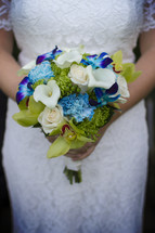 A bride holding a colorful bouquet.