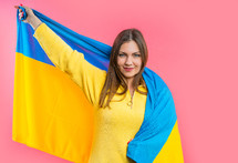 Happy woman with national Ukrainian flag on pink. Ukraine, patriot, victory in war celebration, banner, Independence day. High quality