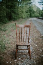 chair in the middle of a country road 