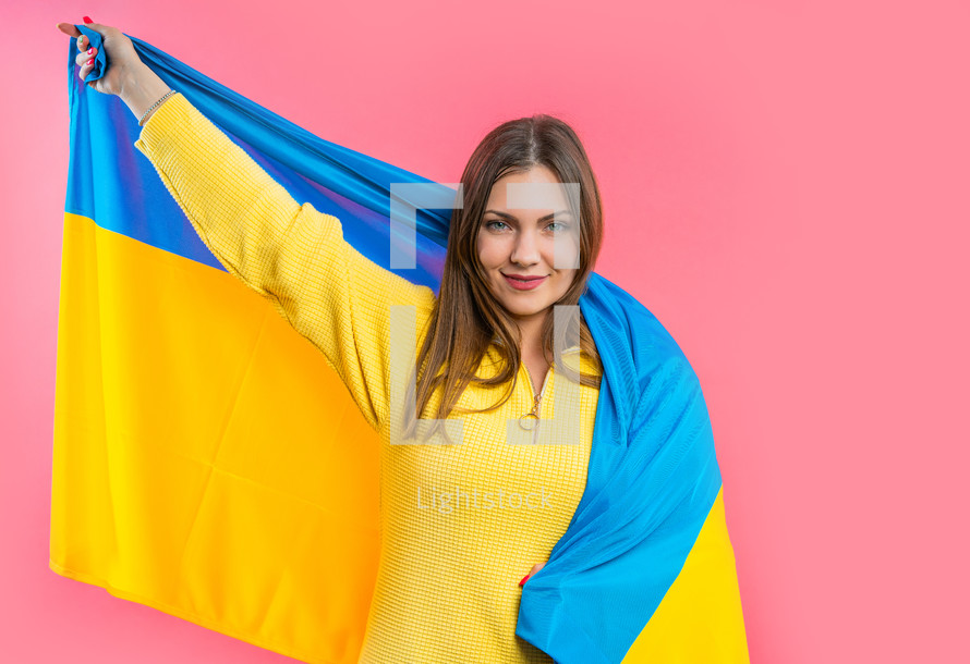 Happy woman with national Ukrainian flag on pink. Ukraine, patriot, victory in war celebration, banner, Independence day. High quality