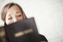 Woman intently reading Bible scripture.