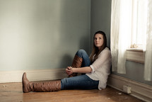 sad teen girl sitting in an empty room 
