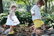toddlers walking through a garden 