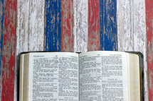 open Bible on weathered red, white, and blue 