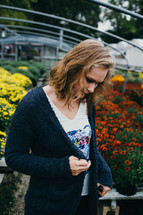 a young woman shopping for mums in a garden center 