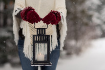 a woman holding a lantern in the snow