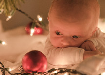 newborn baby and a Christmas ornament 