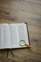 magnifying glass over the pages of a Bible 