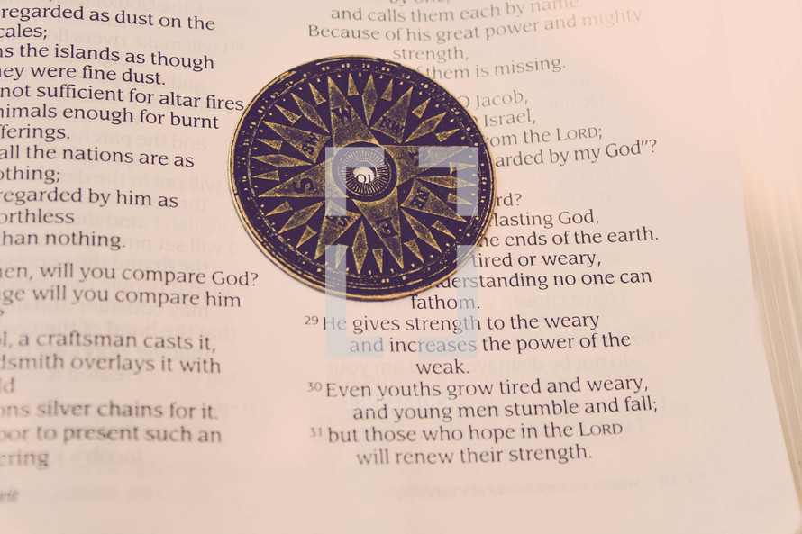 Compass on the page of an open Bible.